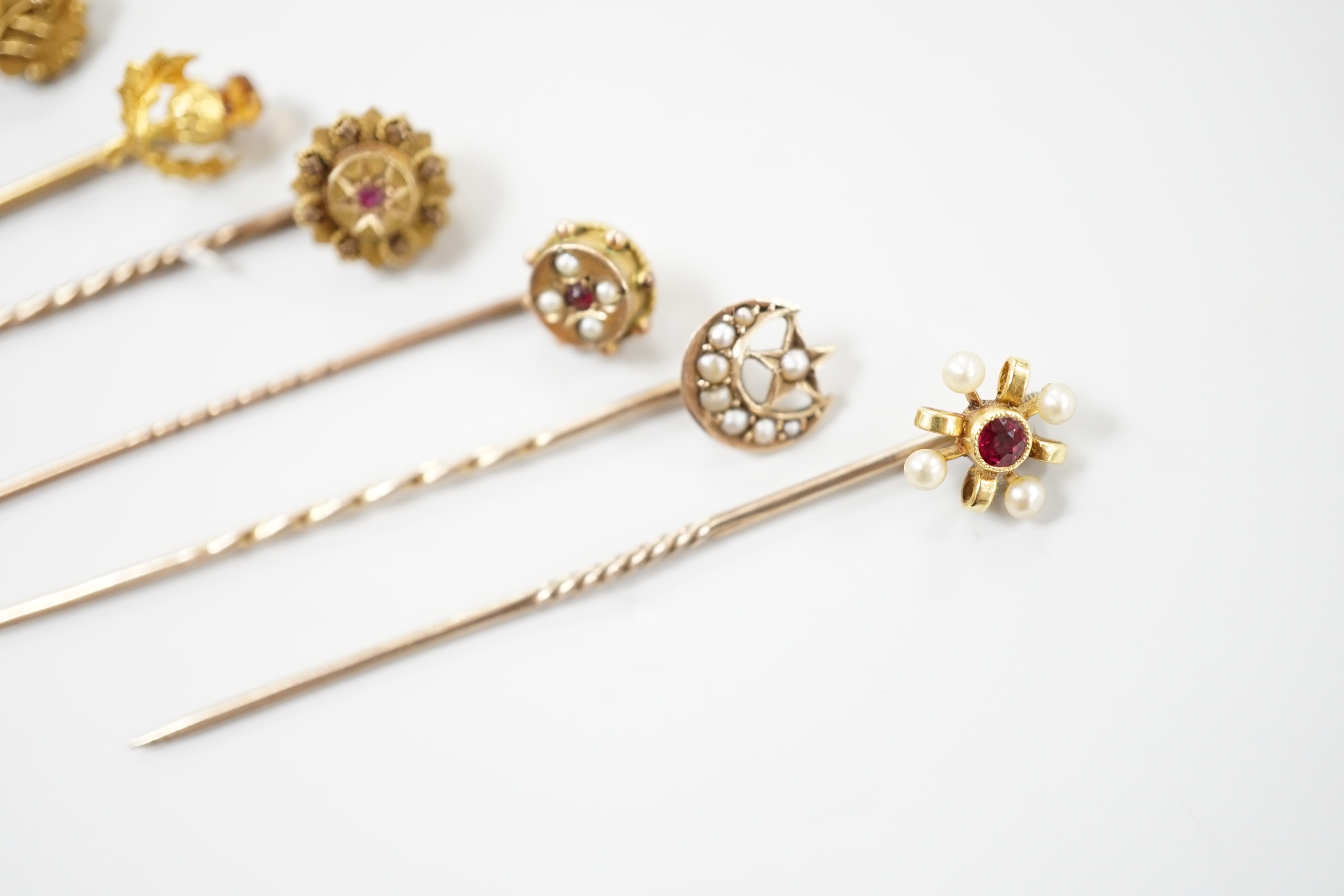 Three early 20th century 15ct stick pins including gem, three similar 9ct stick pins and one other yellow metal and white opal set stick pin, largest approx. 57mm.